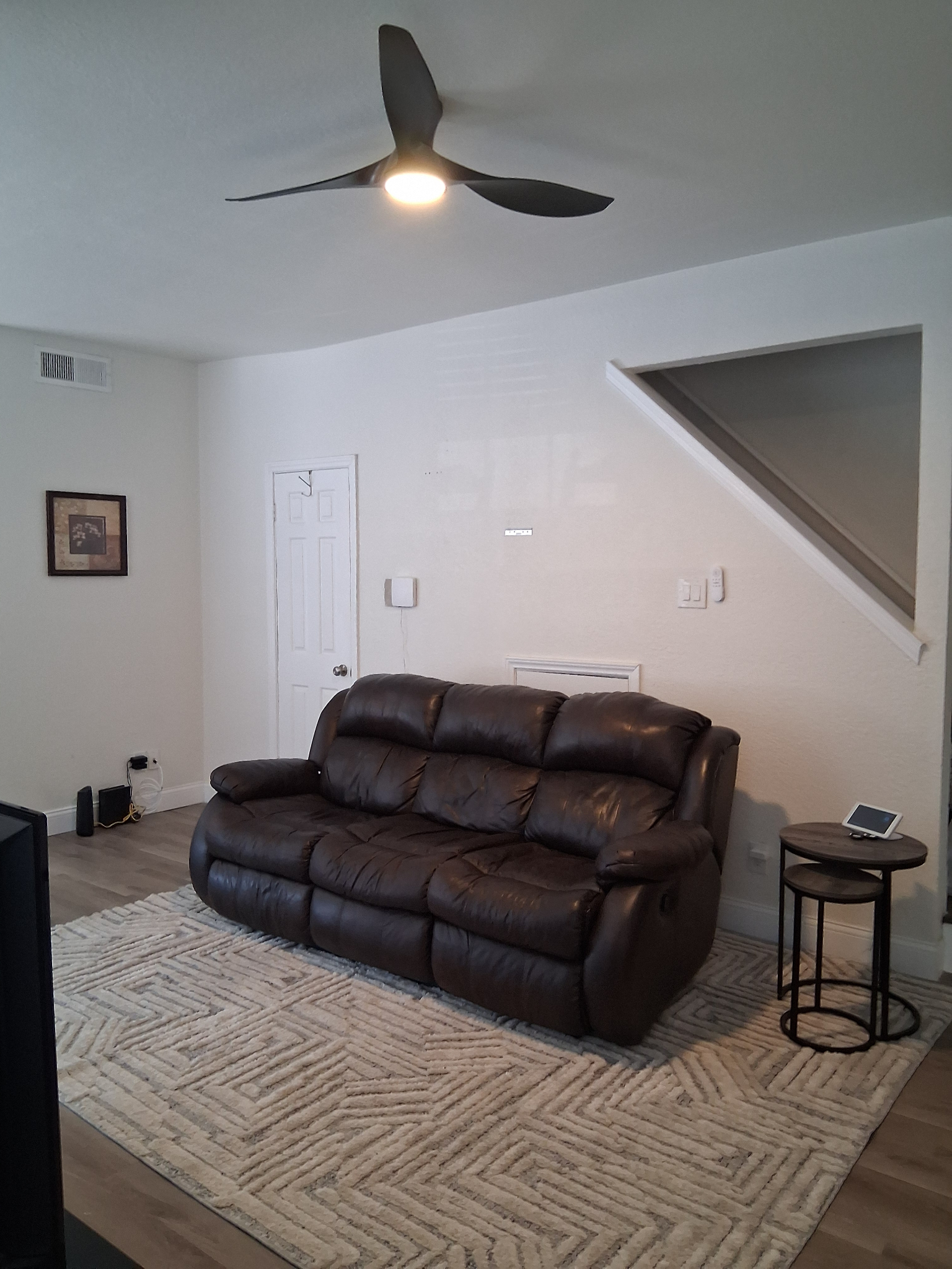 Living room has leather sofa with dual recliners