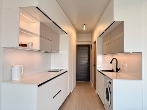 Cook & Dine with Ease! This modern and fully equipped open-plan kitchen comes with a built-in fridge, microwave, rice cooker, tea set, and all essentials for home cooking!