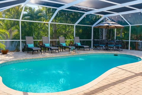 Screened in patio, table with seating for 8 and 2 bedrooms look out onto pool as well as the main living space.
