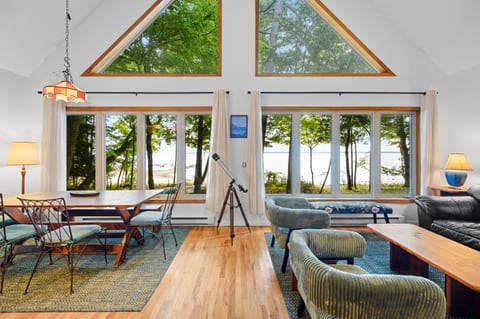 Living room with vaulted ceilings, wall of windows, and bay views