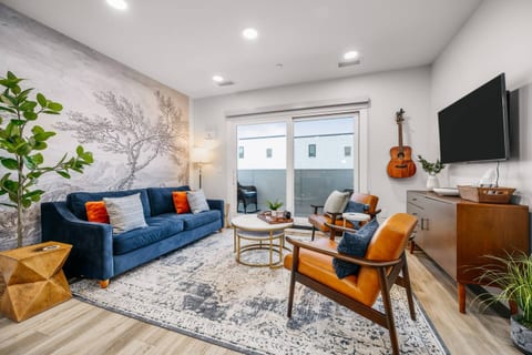 Stylish living room with modern décor, large TV, and balcony access