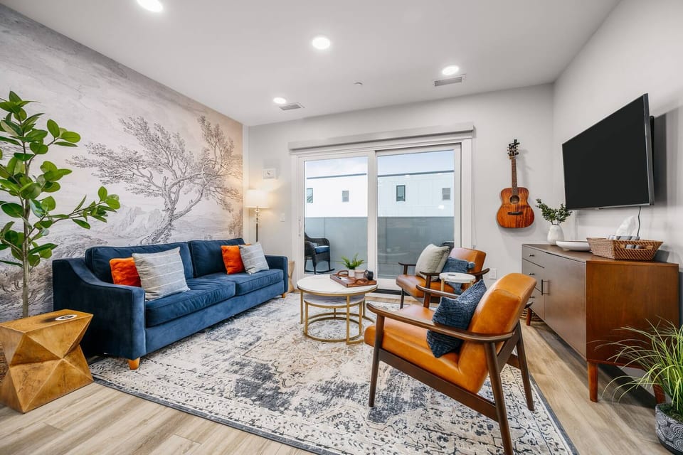 Stylish living room with modern décor, large TV, and balcony access
