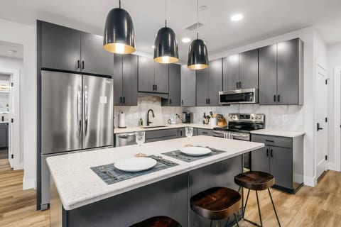 Fully stocked kitchen with stainless steel appliances and breakfast bar