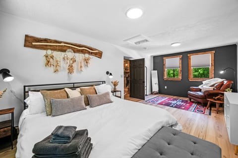 Our expansive KING Primary bed with sitting area and cozy, white linens.