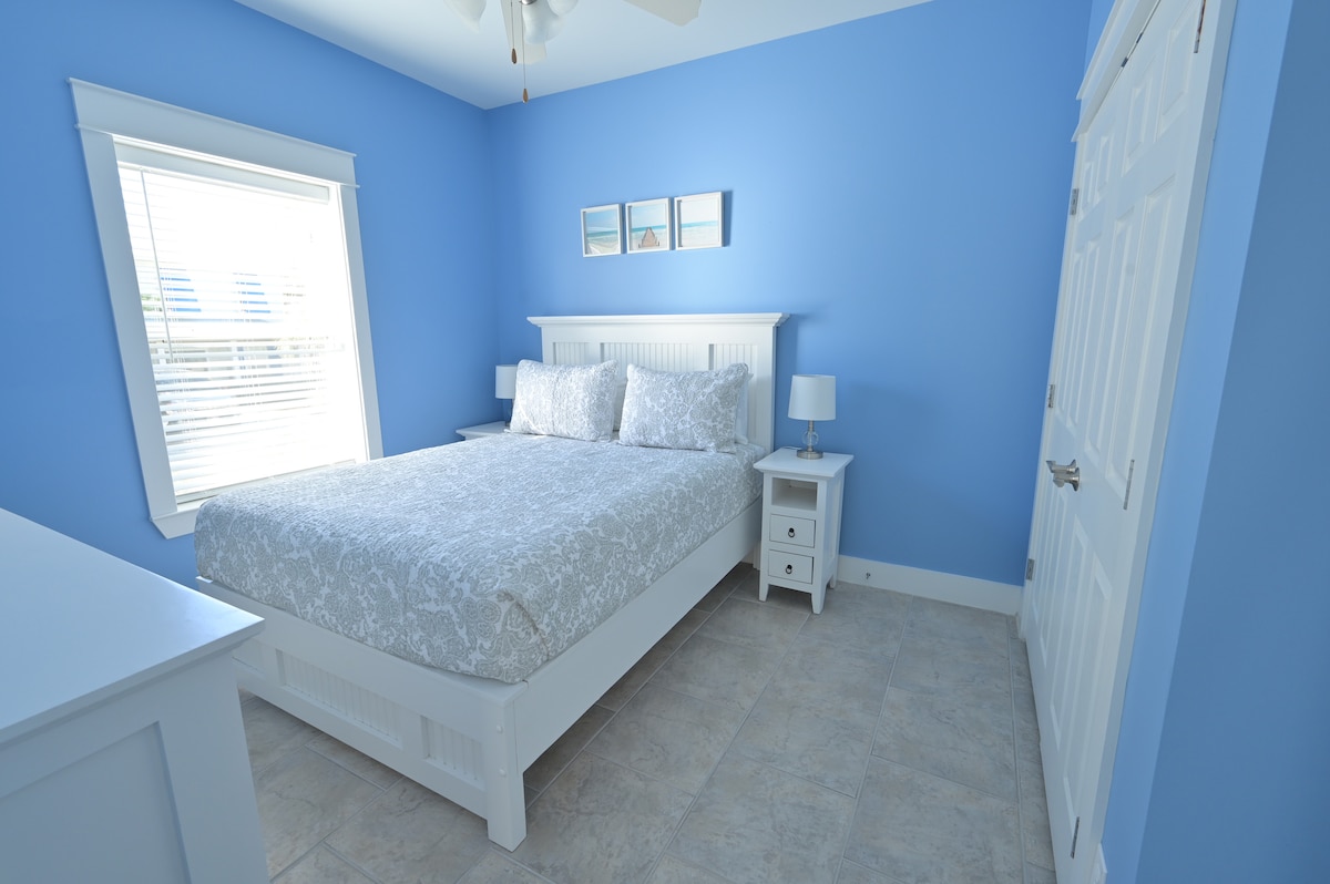 Downstairs bedroom with custom made solid wood night stands, dresser and queen bed with comfortable foam mattress.