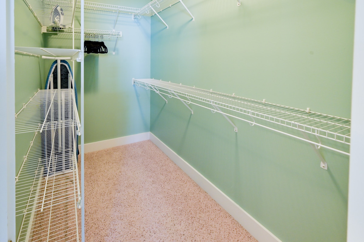 Master closet with iron, iron board, vacuum and plenty of hangers
