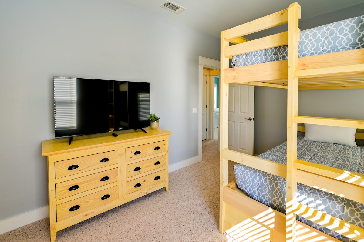 Upstairs bedroom with custom made solid wood dresser, bunk-bed, and 50" TCL Smart TV