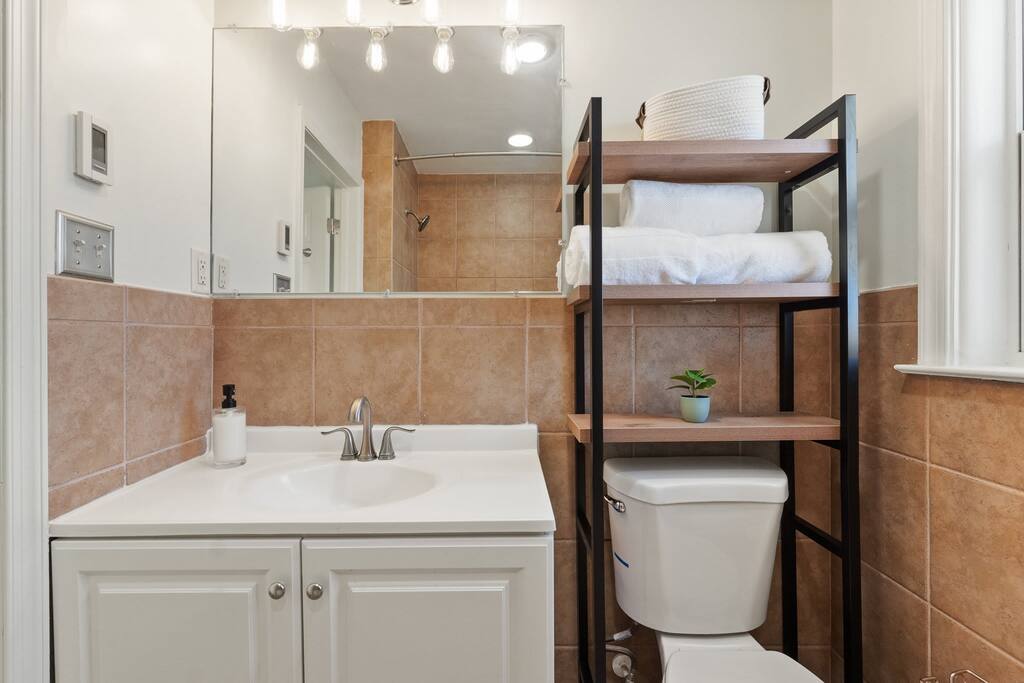 Full bathroom with vanity, toilet, towels and hand soap