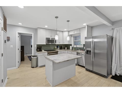 Modern kitchen with island, stainless appliances & chic backsplash