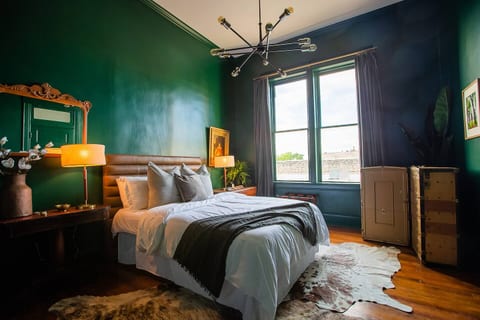Bedroom 2 features a dramatic, moody green vibe.  Guests will enjoy a queen Purple mattress and accessories.  