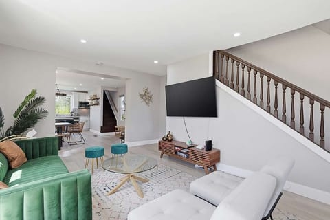 Bright lounge with smart TV, chic seating, and open-plan flow
