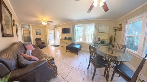 Bright living area with dining space, large windows, and cozy seating