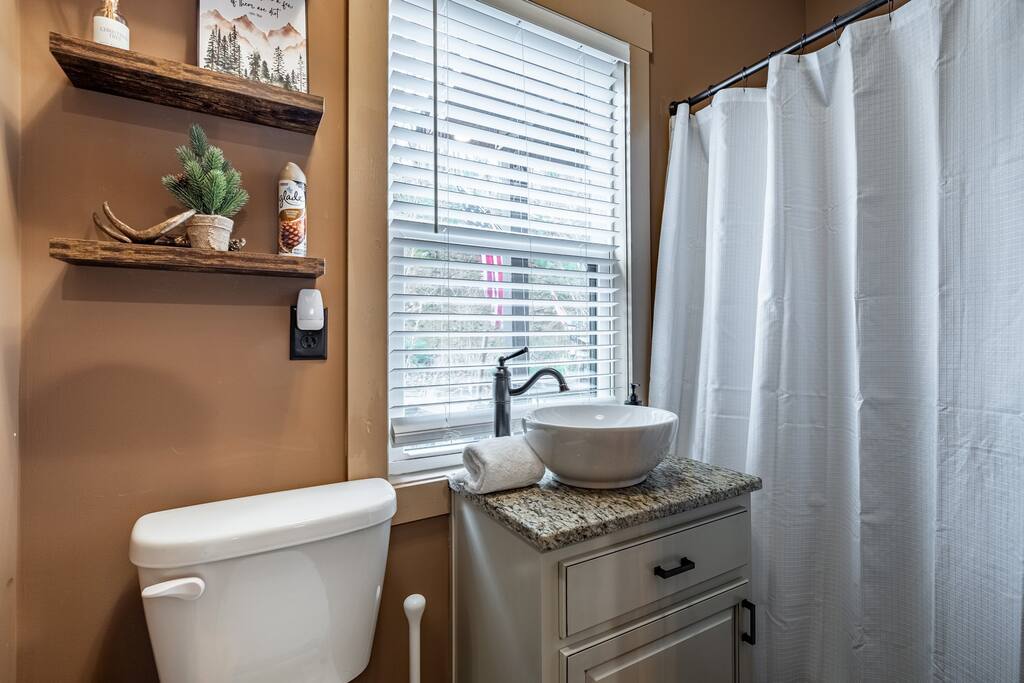 The main floor bathroom is located off the hall between the kitchen and the entry. It includes a full shower, and all the bathroom amenities.