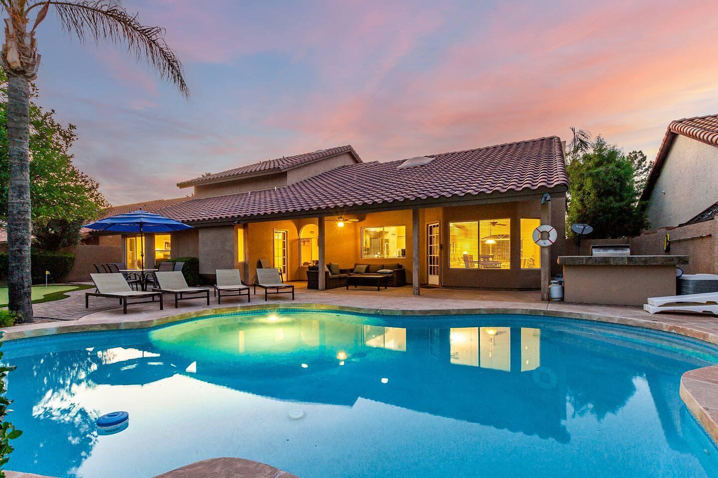 Stunning backyard retreat with sparkling private pool, shaded lounge chairs, and cozy patio seating—perfect for relaxing at sunset or entertaining under the stars.