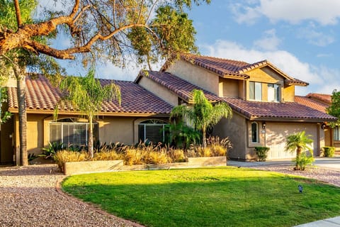 Front lawn and garden view at golden hour, capturing the warm desert sunlight and stunning architecture of your vacation retreat.