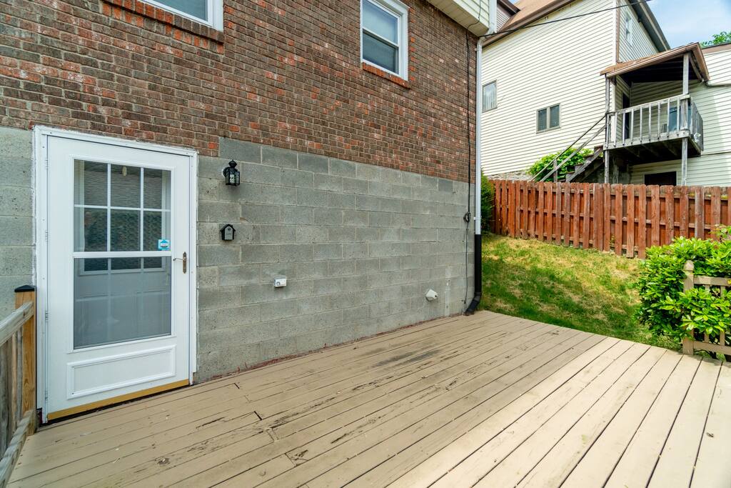 An open backyard deck. Currently unfurnished but plenty of room to get some fresh air and stretch your legs.