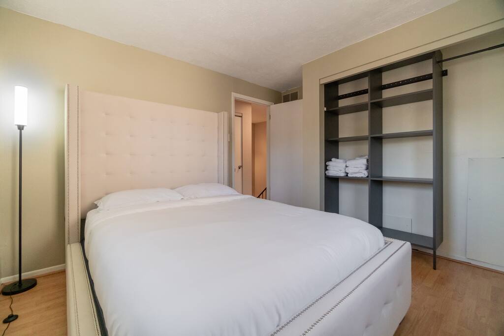 Queen size bed, open closet space, and a lamp with adjustable light settings for your liking.