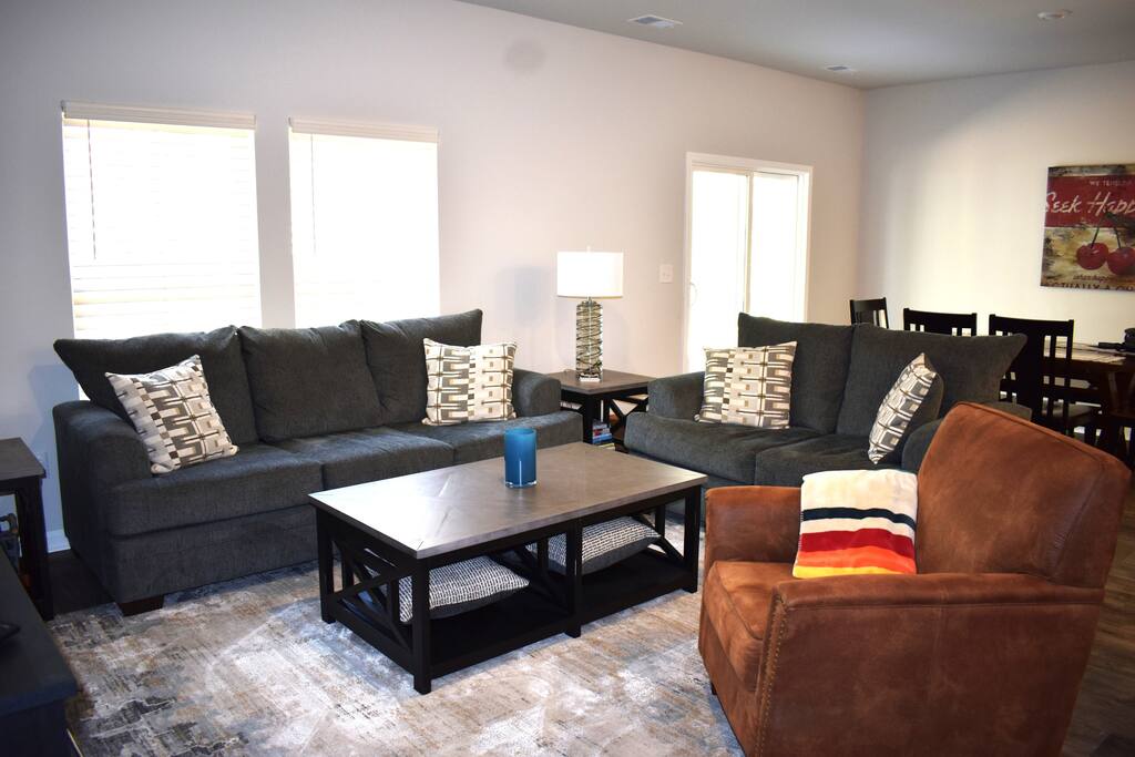 Modern living room with a large smart TV, plush seating, and stylish decor — perfect for streaming your favorite shows, relaxing with family, or enjoying a cozy night in.