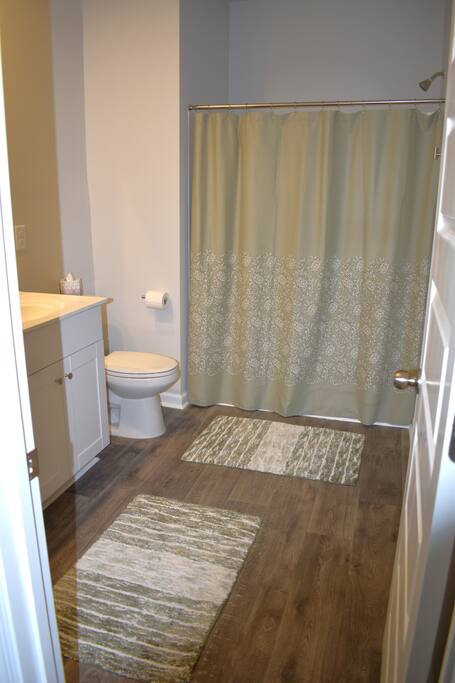 Spacious, sparkling-clean bathroom featuring dual sinks, a full tub/shower combo, and plush bath rugs. Well-stocked with towels and essentials to make your stay as comfortable as home!