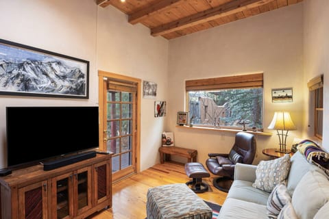 Relax in a cozy living space with plush seating, flat-screen TV, and warm wood accents—ideal for movie nights.