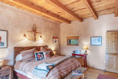 Cozy bedroom with wood-beamed ceilings, southwestern decor, and plush bedding—perfect for restful nights.