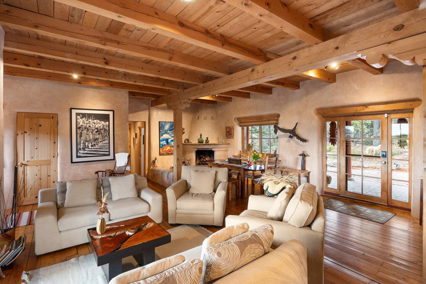 Spacious living area with natural wood beams, comfy seating, and lots of light—great for gathering.