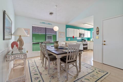 Welcome to your cozy coastal cottage! Unwind and enjoy a delightful meal at the farmhouse-style dining table, just steps away from a fully equipped kitchen. Perfect for creating lasting memories!