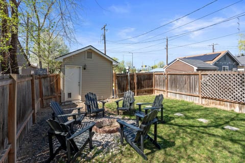 Enjoy a cozy night in by the fire pit! This inviting backyard space is perfect for unwinding with friends or family on comfortable Adirondack chairs.