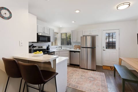 You'll love this fully-equipped kitchen with stainless steel appliances, a cozy breakfast bar, and stylish barstools, perfect for a quick snack or a morning coffee.