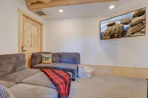 Comfortable sectional seating with soft lighting, cozy cabin touches, and a large TV for relaxing after your mountain adventures.