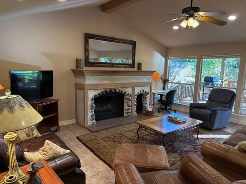 Relax in your cozy lake house living room with a stunning fireplace and private deck. Perfect for a peaceful retreat to unwind and connect with nature.