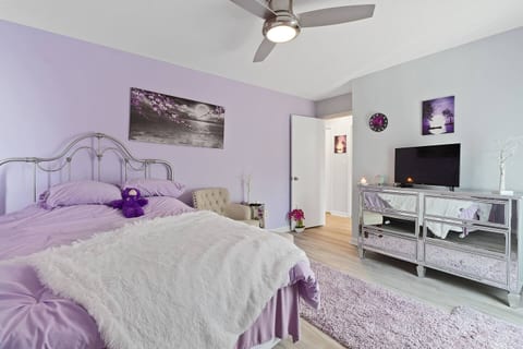 Escape to this tranquil, lavender-hued bedroom. Relax in the plush bed with a soft throw, catch up on shows, or simply unwind in your cozy, private retreat.