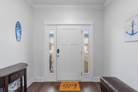 Bright coastal foyer with smart lock, bench seating, and console.