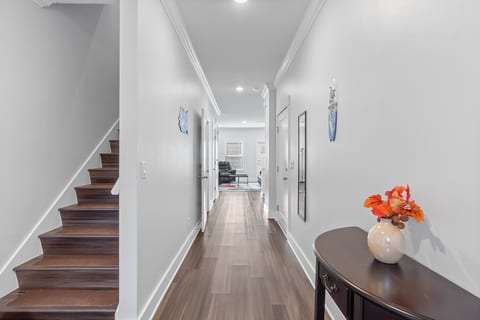 Sleek entry hall with wood floors, crown molding, and open flow to living.