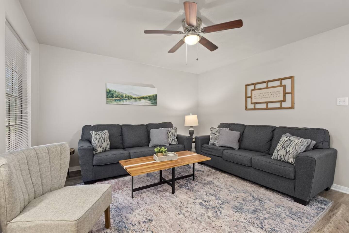 Bright living room with comfortable seating, ceiling fan, and cozy décor, perfect for relaxing.