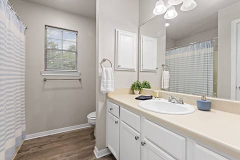 Bathroom with bright lighting, mirror, and fresh towels.