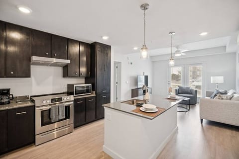 Bright, open living with island seating, cozy sofa, and smart TV—your Texas escape starts here