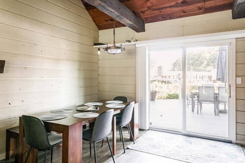Imagine yourself enjoying a meal with loved ones at this charming lake house. This dining area seamlessly connects to a sunny patio, perfect for indoor-outdoor living.