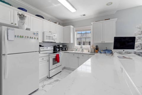 This modern and fully-equipped kitchen is designed for you. With sleek white cabinets and spacious quartz countertops, you'll have everything you need to prepare meals. Cook, dine, and feel at home.