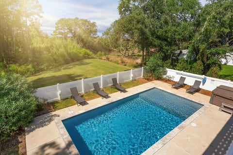 Dive into this stunning heated saltwater pool, surrounded by lush greenery and sunlight. Lounge on chaise chairs, enjoy serene views, and relax in the hot tub near your Corolla, NC soundfront retreat. Open May–Oct and ideal for a family escape.