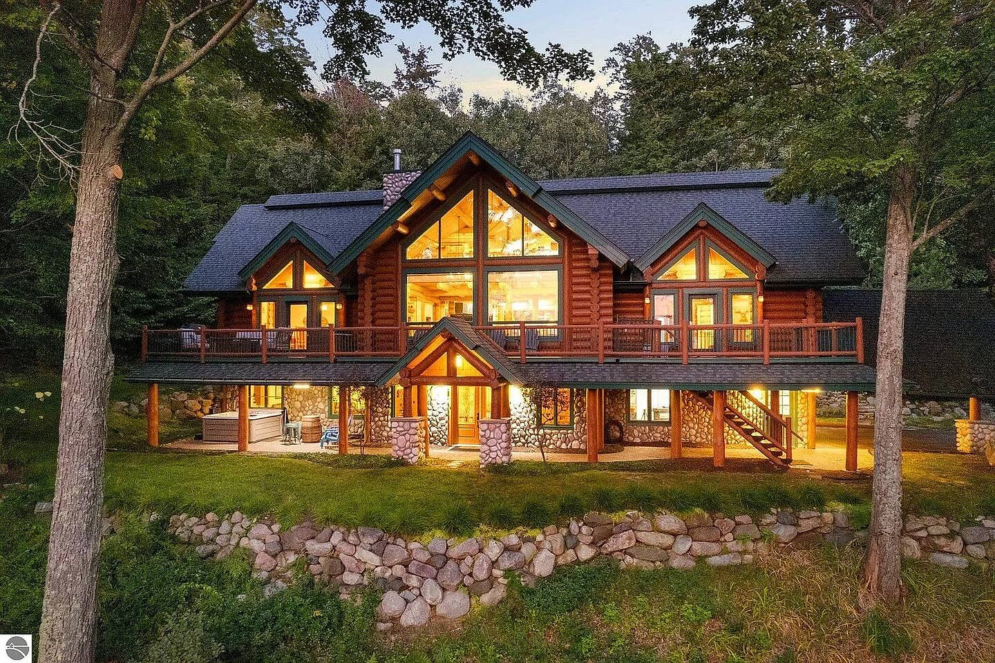 Gorgeous custom log cabin with floor-to-ceiling windows, wraparound deck, and peaceful forest views. Perfect for relaxing getaways with rustic charm, modern comfort, and stunning architecture.
