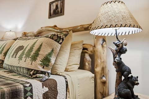 Cozy rustic bedroom with log bed, woodland quilt, and charming cabin decor