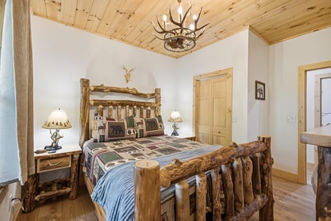 Rustic cabin bedroom with log bed, pine ceilings, and lodge-style charm