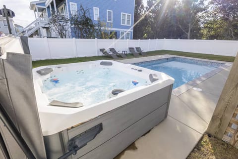 Relax in your private fenced backyard featuring a sparkling saltwater pool and bubbling hot tub and outdoor shower. Perfect for sun-soaked afternoons, evening dips, and creating unforgettable memories just steps from the beach.