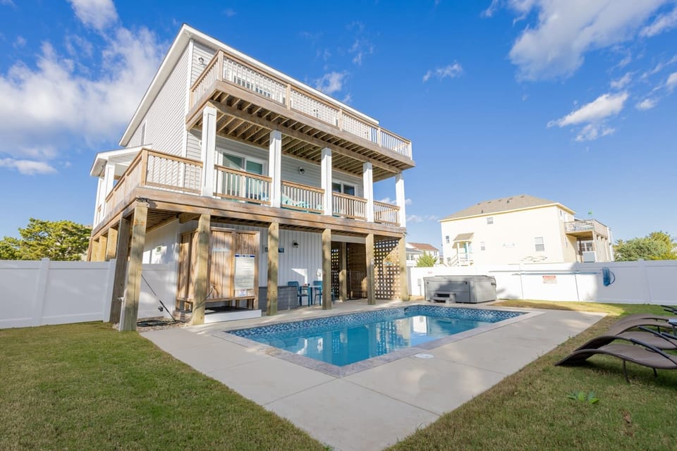 Relax in your private fenced backyard featuring a sparkling saltwater pool and bubbling hot tub and outdoor shower. Perfect for sun-soaked afternoons, evening dips, and creating unforgettable memories just steps from the beach.