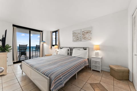 Spacious master bedroom with king bed and private balcony overlooking the turquoise Gulf