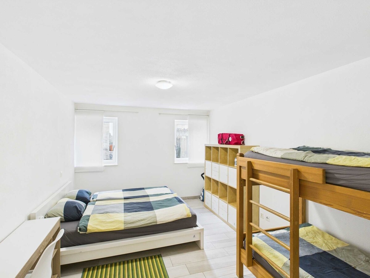 Camera da letto ampia con letto matrimoniale e letto a castello, ideale per famiglie o ospiti. L'ambiente spazioso e luminoso offre comfort, relax e funzionalità, rendendola perfetta per un soggiorno pratico e accogliente.