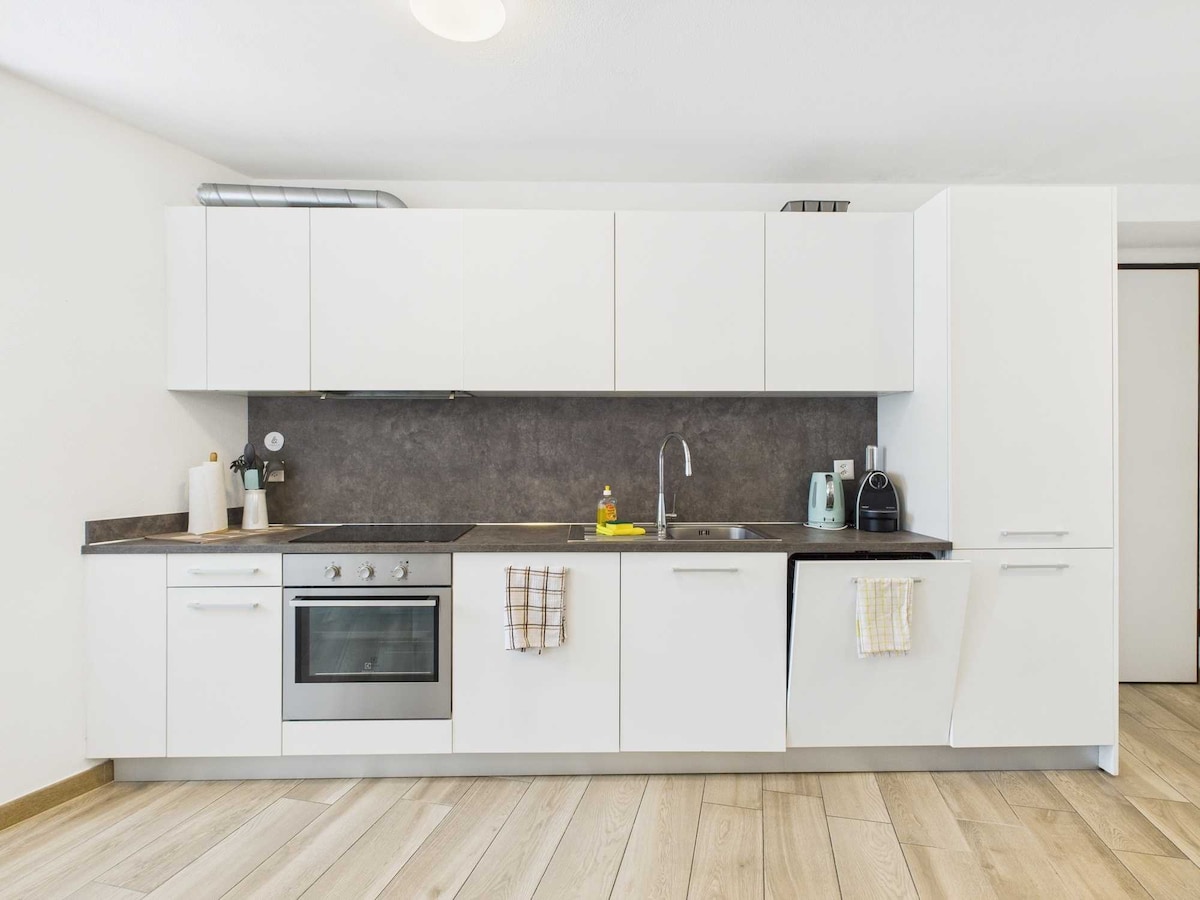 La cucina compatta, moderna e funzionale, è progettata per sfruttare al massimo lo spazio disponibile. Equipaggiata con elettrodomestici all'avanguardia, offre soluzioni pratiche e un design elegante e minimalista, ideale per ogni esigenza culinaria.