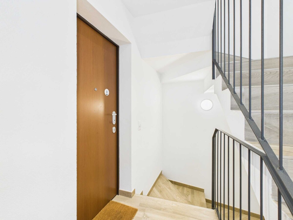 L'atrio, con la sua comoda porta d'ingresso al primo piano, è luminoso e spazioso. La porta, solida e pratica, garantisce un accesso facile e confortevole, creando un ambiente accogliente che conduce alla zona abitativa.