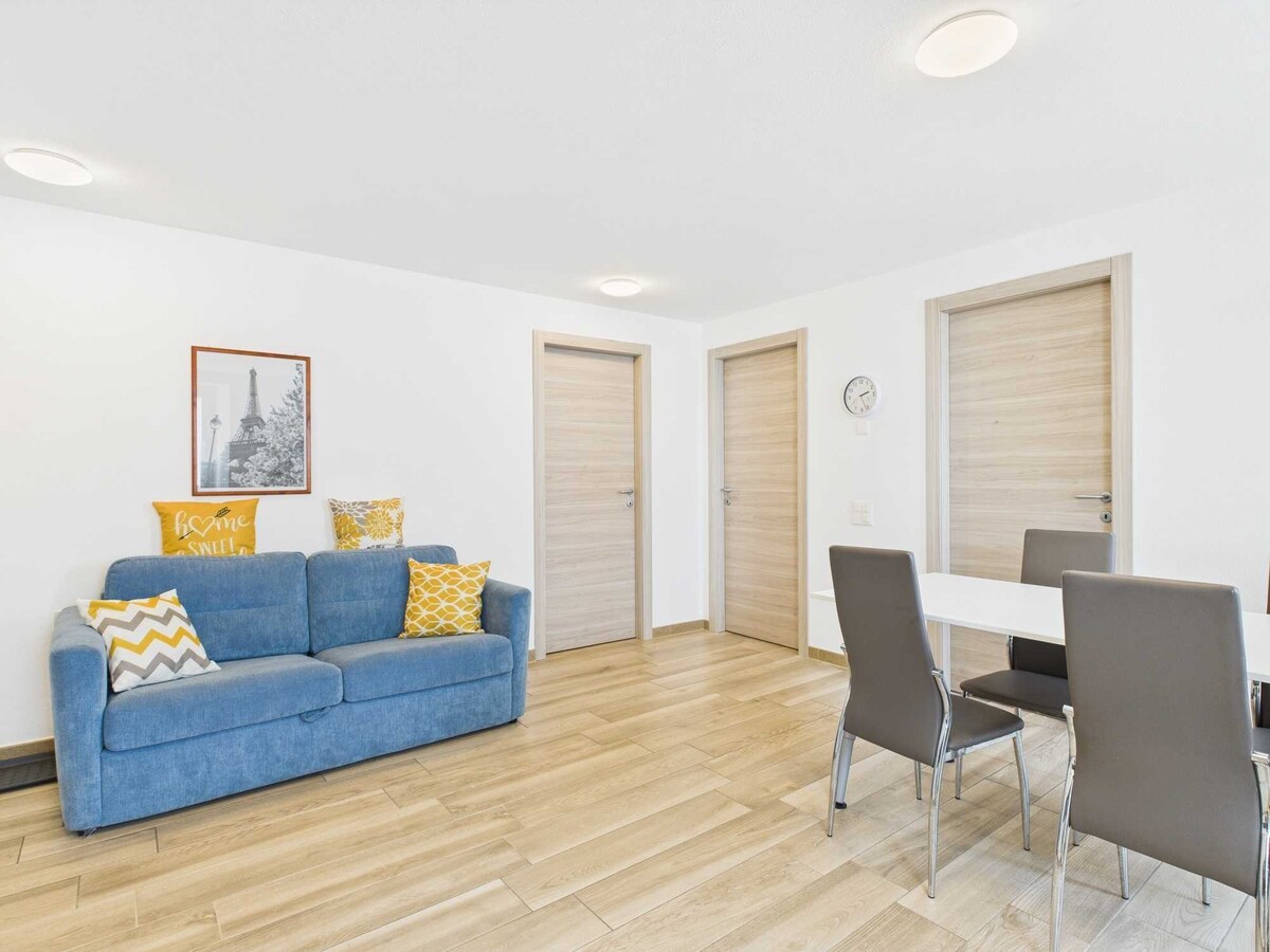 Il soggiorno è spazioso e luminoso, con grandi finestre che inondano l'ambiente di luce naturale. L'arredamento moderno e la disposizione funzionale degli spazi creano un'atmosfera accogliente, ideale per il relax e la convivialità.